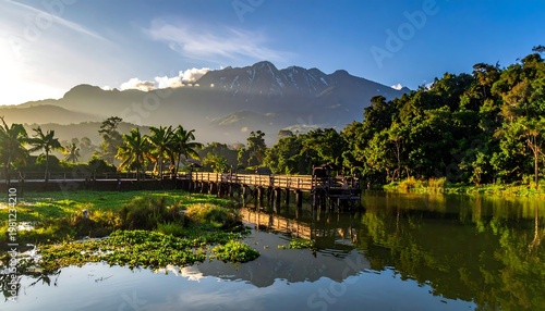 Serene landscape featuring a lake reflecting a distant mountain and lush green vegetation under a blue sky