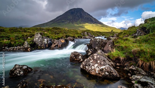 Serene landscape showcasing a flowing stream beneath a large, grass-covered mountain under a partly cloudy sky