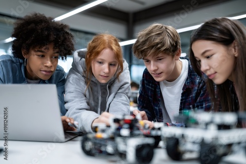 Diverse group of teenage students collaborating on a robotics project in a classroom. Multiethnic friends working together on a STEM education assignment