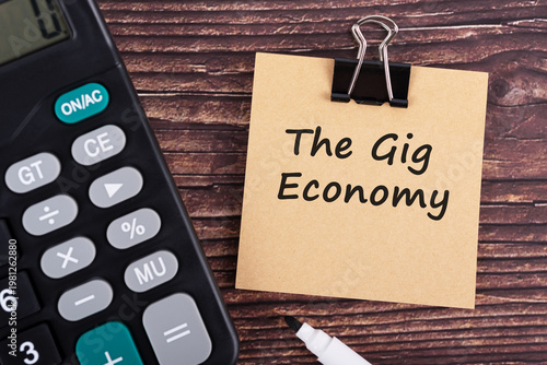 Photos Calculator and The gig economy text on brown memo pad
