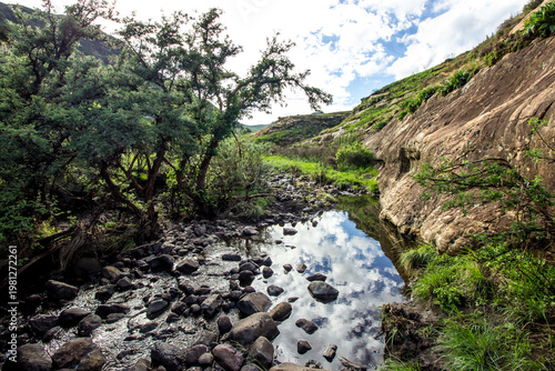 Cloud fill sky reflecting in a small stream in the Drakensberg Mountains, Golden Gate Highlands National Park, South Africa.