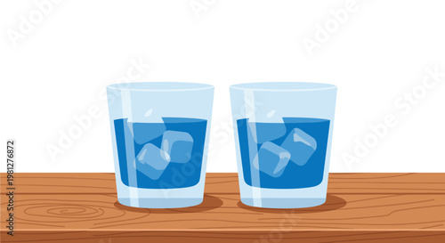 Two refreshing glasses of vibrant blue liquid filled with translucent ice cubes rest upon a polished brown wooden tabletop against a white backdrop.