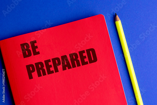 Be prepared message on red notebook with pencil on blue background, motivation planning