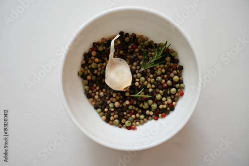 Clean top view of garlic, pepper mix and rosemary in a bowl, symbolizing natural immunity boosting ingredients and healthy eating lifestyle