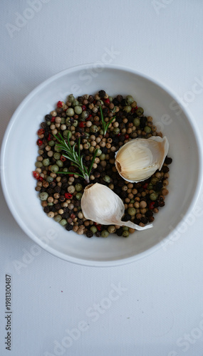 Flat lay of garlic cloves, rosemary and colorful peppercorns, perfect for nutrition blogs, wellness articles and healthy diet content