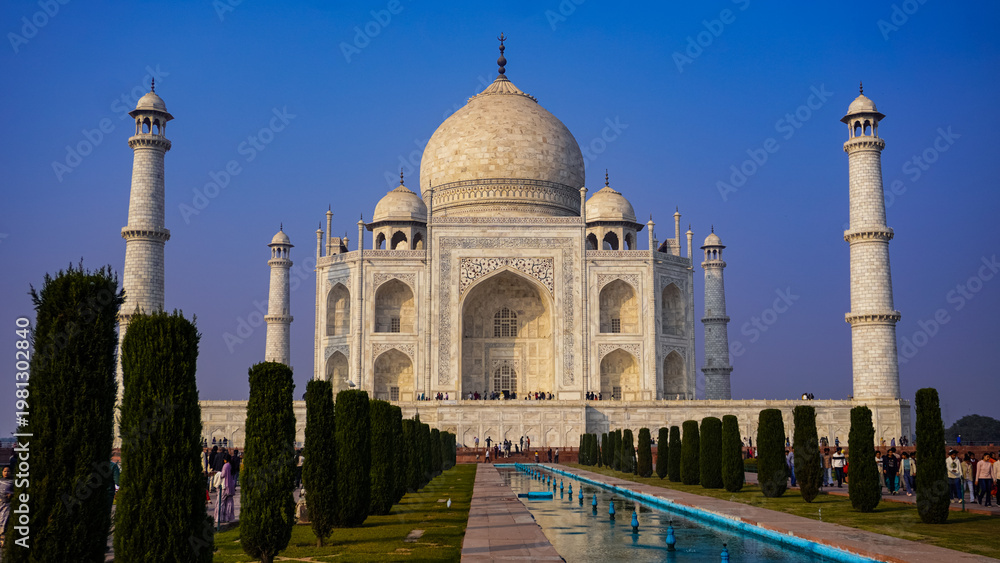 Naklejka premium The Taj Mahal at sunrise with reflections in the garden water channel, Agra, Uttar Pradesh, India