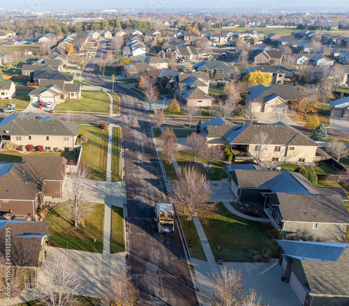 aerial view of a garbage truck going down a residential area in the morning