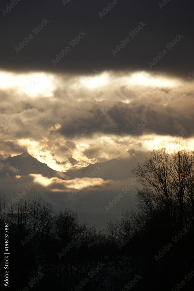 Obraz premium Sunset in the mountains on a cloudy day.