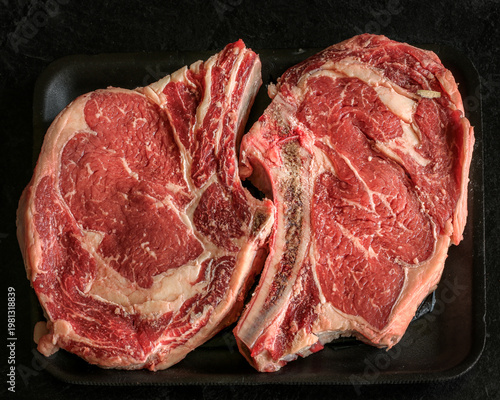 Fresh rib eyed steak with a a black background.