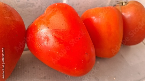 Fotografia Three vibrant red tomatoes arranged neatly on a surface to represent healthy org