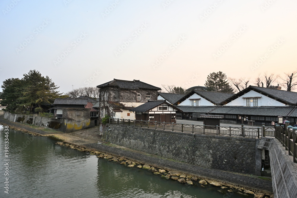 Obraz premium 山居倉庫と新井田川と夕焼けの風景（山形県酒田市）