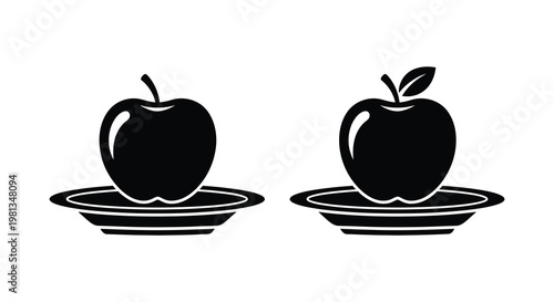 Two dark apples displayed on plates a striking silhouette