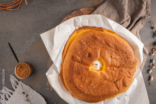 Wallpaper Mural Top down view of a fluffy golden Pao de Lo sponge cake on white parchment paper over a dark rustic stone surface with cocoa powder and cozy kitchen decor Torontodigital.ca