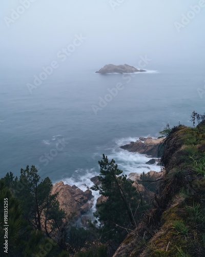 Misty Morning Coastal Landscape with Crashing Waves, Foggy Sea, and Rocky Island, Moody Travel View