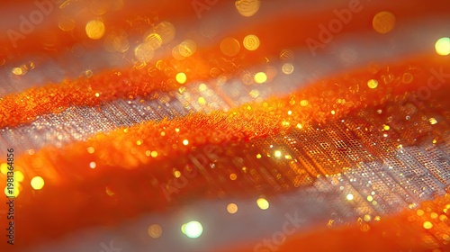 Intense close up of shimmering orange fabric texture illuminated by golden sparkling lights