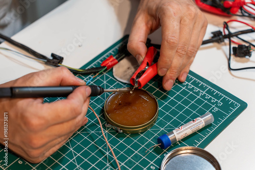 Hobbyist assembling DIY electronic project with wires and tools
