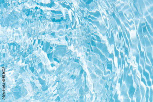 Bluewater waves on the surface ripples blurred. Defocus blurred transparent blue colored clear calm water surface texture with splash and bubbles. Water waves with shining pattern texture background.