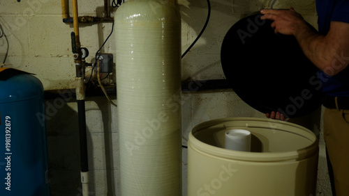 A Plumbing or Well Specialist Looks inside Salt Tank in Indoor Filtration System