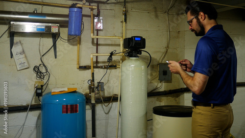A Plumbing or Well Specialist Takes Notes on Indoor Water Filtration System 