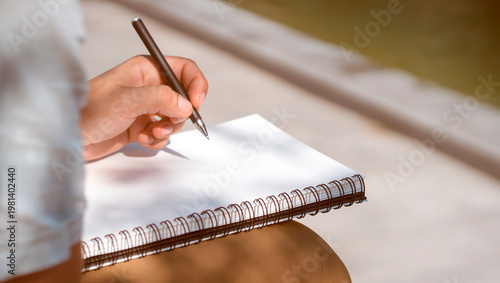 Man is writing notes on a white paper, hands closeup.