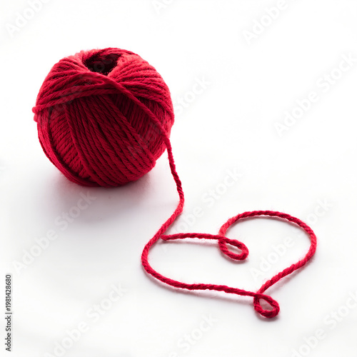Red yarn ball with heart shaped thread on white background