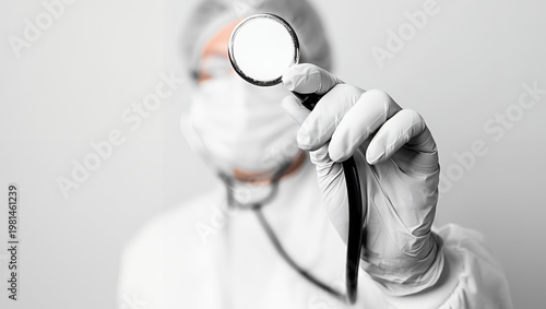 Doctor in face mask holding stethoscope in clinic with white background