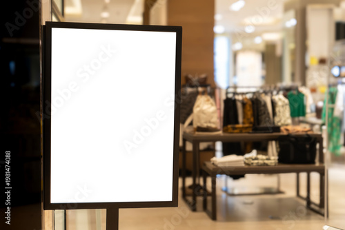 Blank illuminated sign board at modern fashion retail store entrance