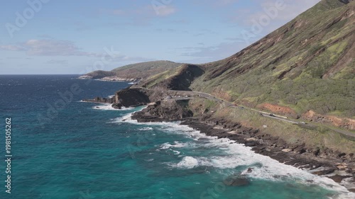 Aerial Flight Along Rugged Hawaiian Coastline with Mountain Road and Sandy Beach
