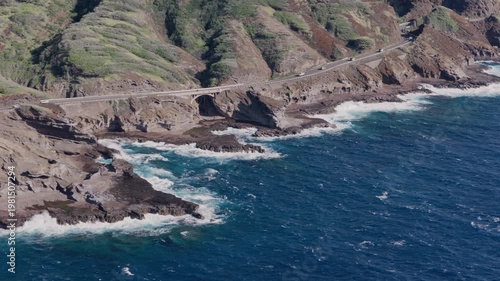 Aerial View of Coastal Bridge and Winding Mountain Road Along Rocky Hawaiian Shoreline