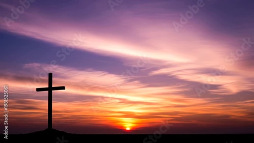 Silhouette of a Christian Cross Against a Vibrant Sunset Sky.