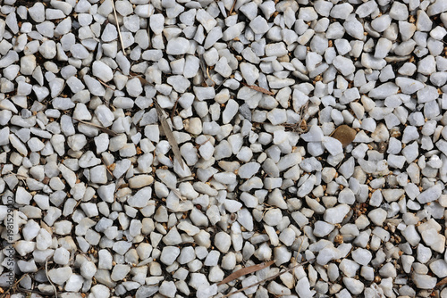 Overhead full-frame texture of small, crushed white quartz pebbles and decorative garden gravel