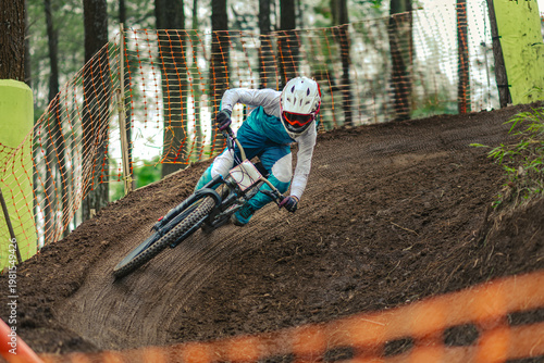 Mountain Biker Racing Downhill Through a High-Speed Berm on Dirt Track