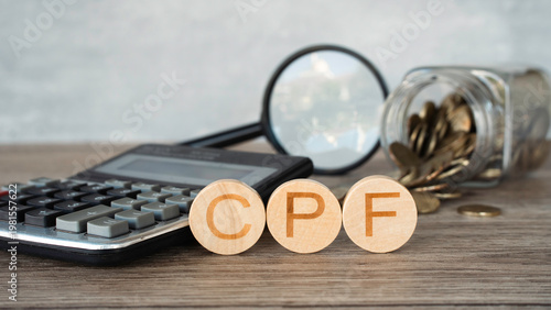 Tableau sur toile Central Provident Fund CPF word on wooden blocks with calculator and coins jar background