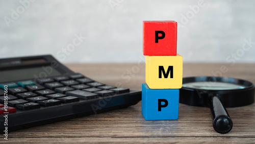 Obraz na plátne Project Management Professional PMP acronym on colorful toy blocks with calculator and magnifying glass