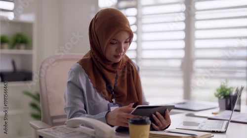 Asian adult woman professional business work modern office setting using digital tablet technology productivity focused tasks