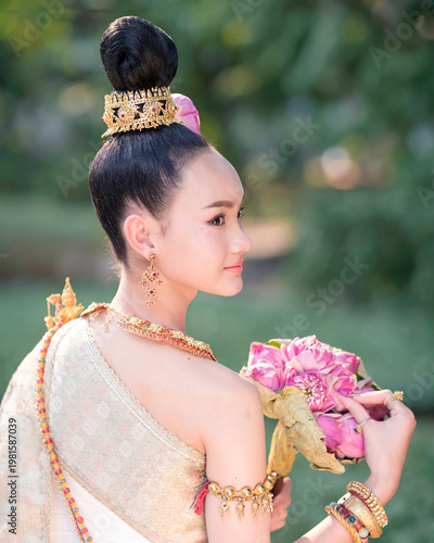 Thai Woman in Traditional Costume Holding Pink Lotus, Elegant Cultural Portrait.