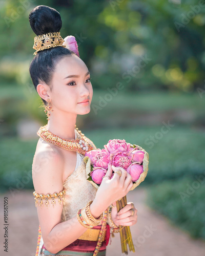 Thai Woman in Traditional Costume Holding Pink Lotus, Elegant Cultural Portrait.