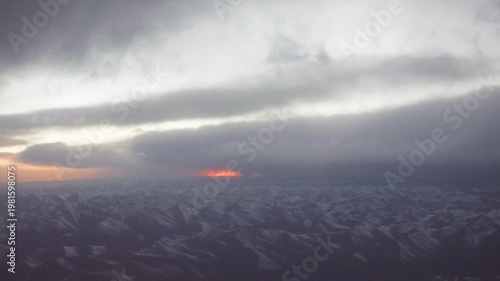 Beautiful sunset and snow mountains viewed from the window of airplane, aerial view Tibet landscapes, 4k slow motion footage b roll shot, travel concept.