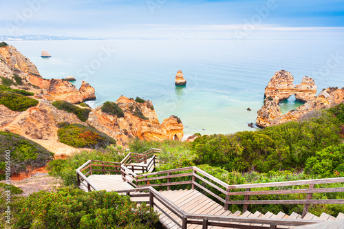 Yellow sandstone rocks and turquoise water on the coast of Atlantic ocean in Algarve, Portugal. Beautiful seascape at foggy morning.