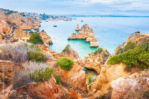 Yellow sandstone rocks and turquoise water on the coast of Atlantic ocean in Algarve, Portugal. Beautiful seascape at foggy morning.