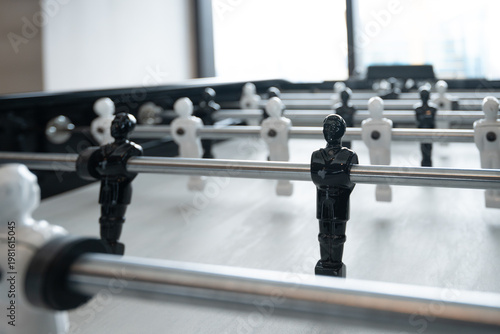 Foosball table with black and white players in the room.