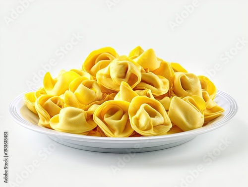 Heap of golden tortellini on white plate, against a bright white background