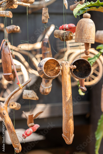 Quadro em tela A unique collection of handcrafted wooden fertility symbols and charms hanging outdoors, featuring various phallic carvings and natural elements