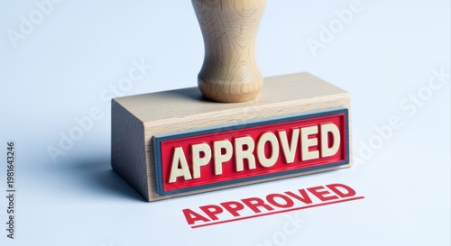 Wooden rubber stamp with the word 'Approved' imprinted in red ink, signifying endorsement and confirmation