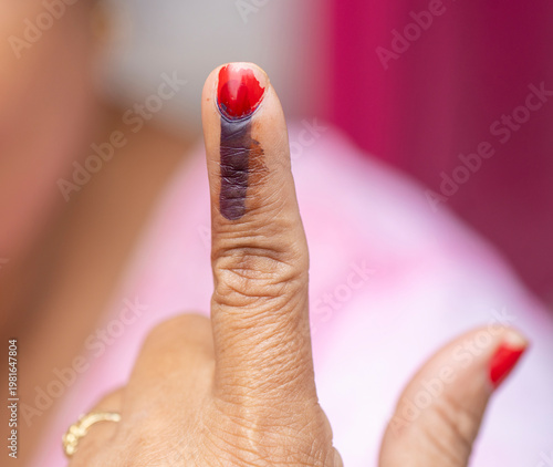 An Indian voter displays an ink-marked finger after casting her vote, the indelible ink signifying participation in the democratic process