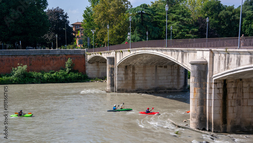 Kayaking in the river Adige in Verona passing underneath the Garibaldi bridge.