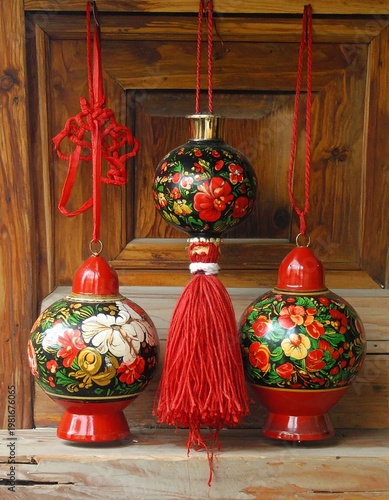 Three colorful hanging ornaments with floral designs on a wooden background