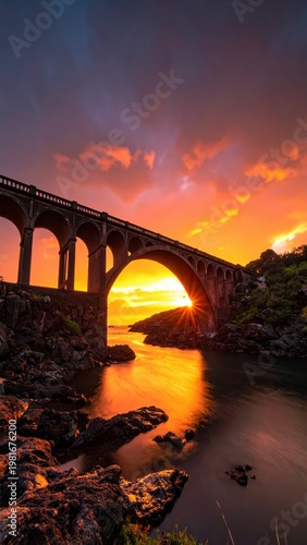 Vibrant Sunset Over Bridge with Reflection in Calm Waters