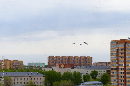 Military helicopters fly over the city