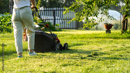 Photography Sunlight glints off the grass as a person pushes a lawn mower
